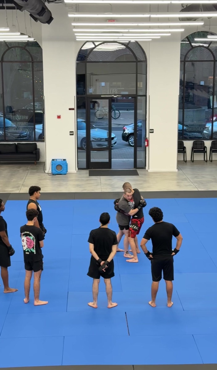 Coach instructing a line of kids on the mats