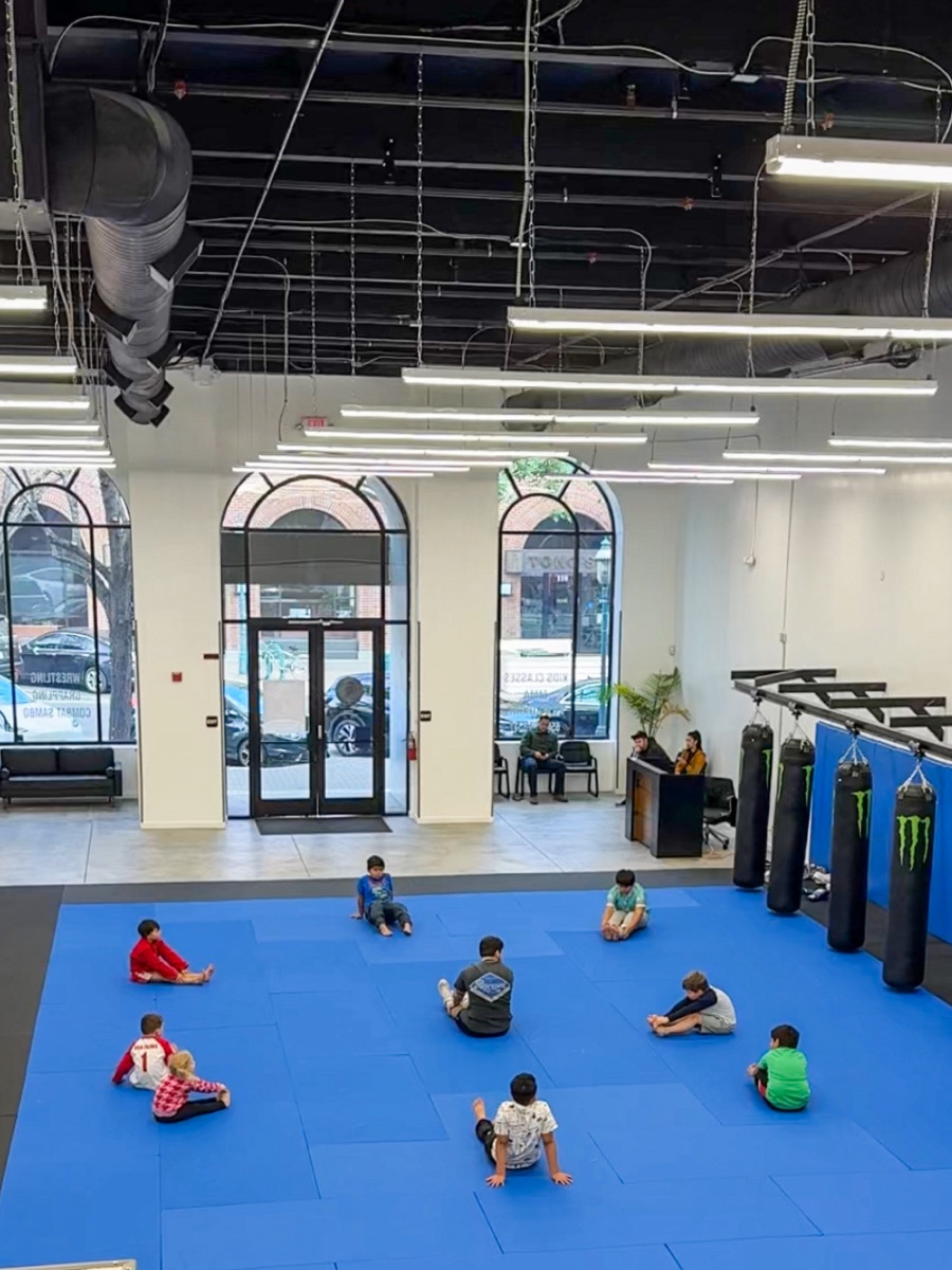 Kids stretching together before class at Spartan Combat Sports