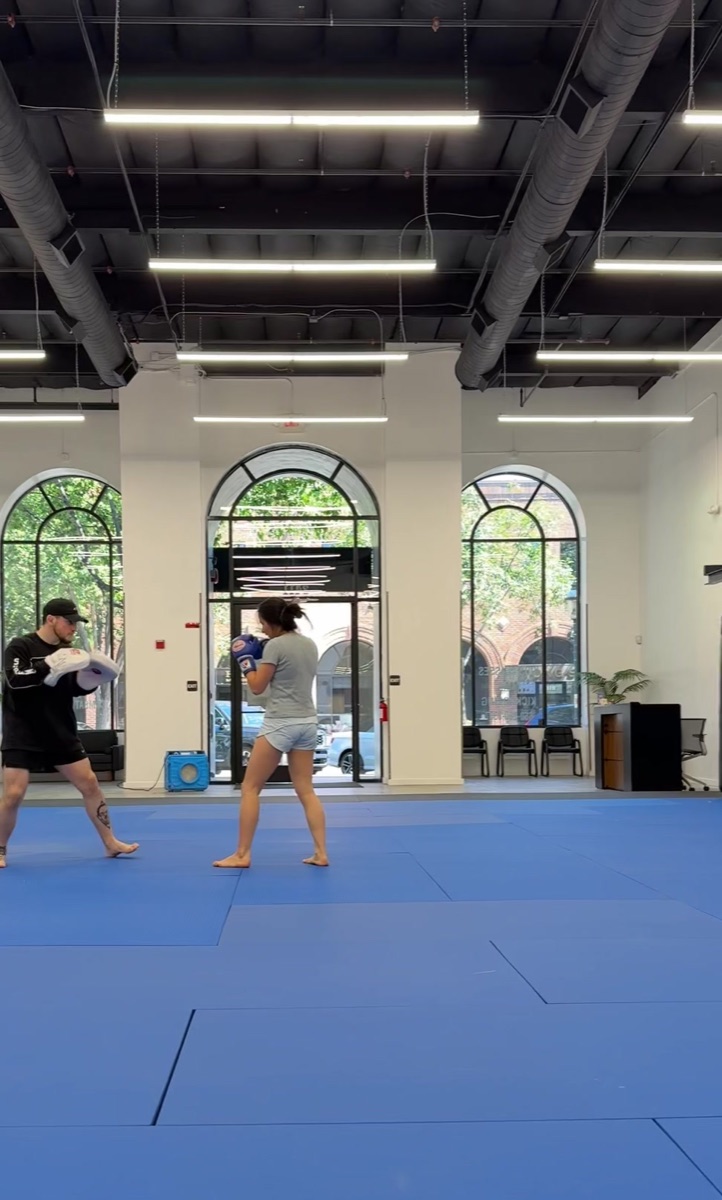 Two adults sparring on the mats
